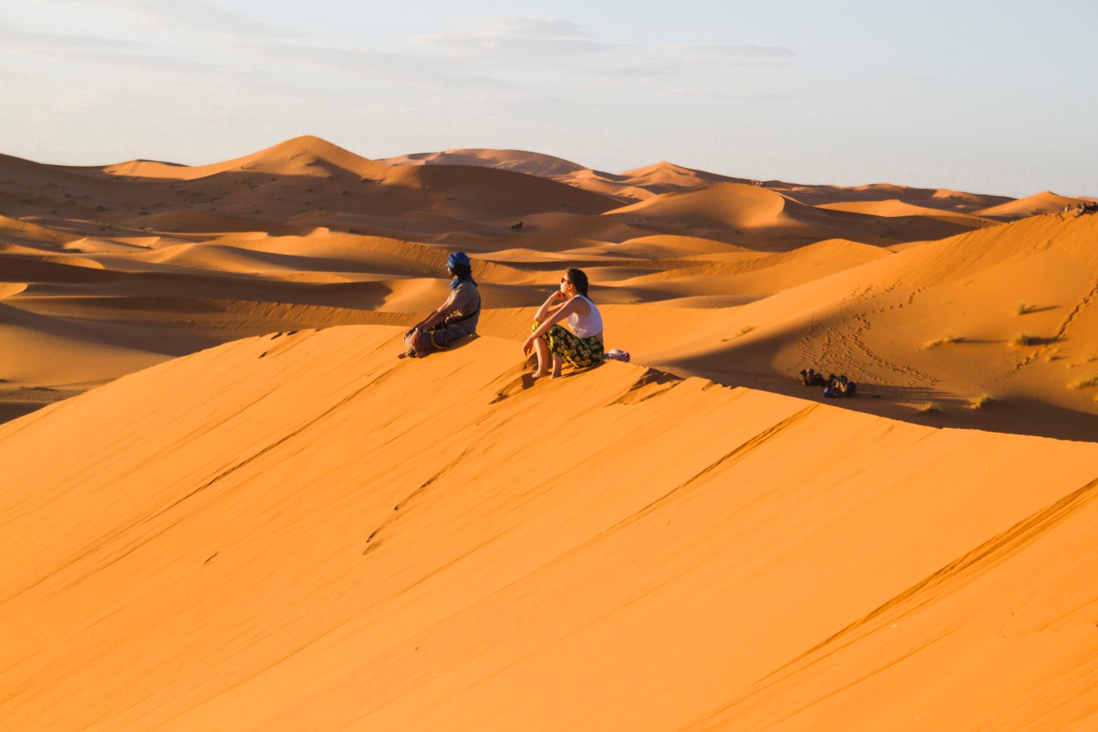 extreme-long-shot-two-people-sitting-top-dune